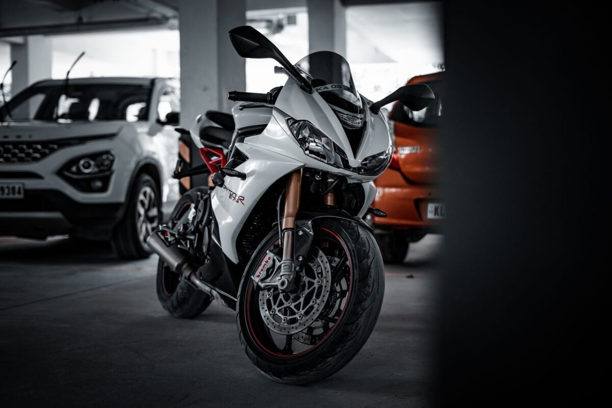 Close-up of a sleek white motorcycle parked indoors, showcasing its design and features.
